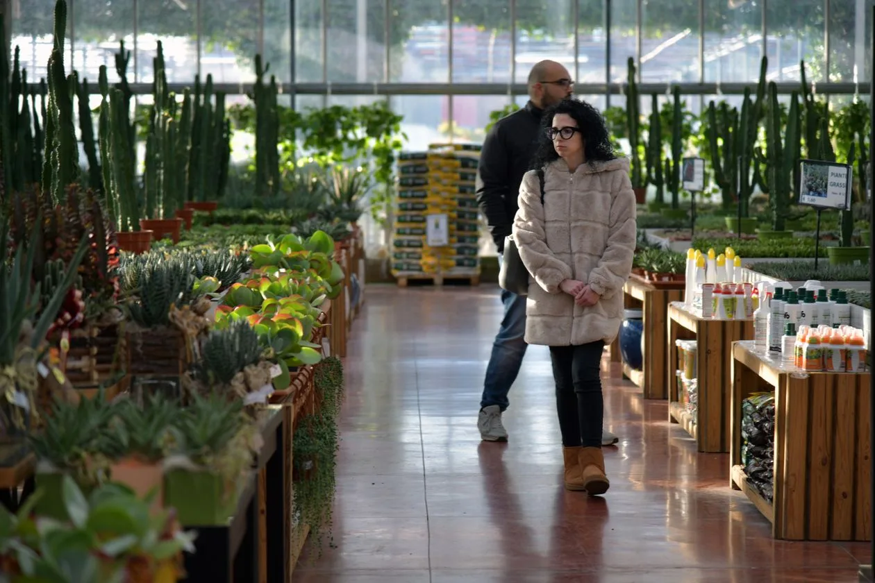 Customers browsing plants and gardening supplies inside a garden center
