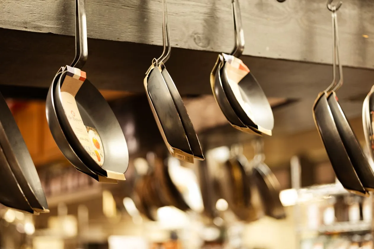 Commercial pans on display for sale in a restaurant supply store