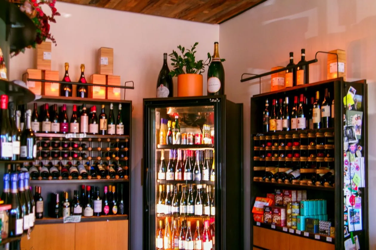Wine shop interior with bottles displayed on shelves and in a chilled case